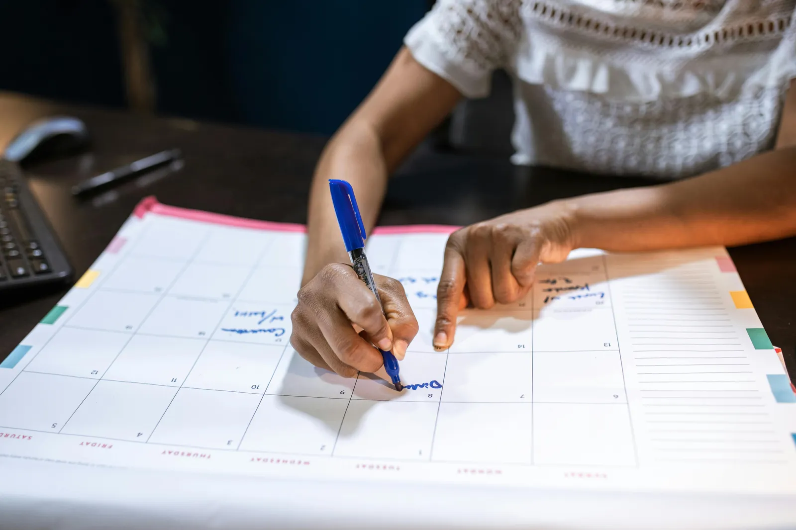 Practitioner planning a new social value measurement cycle at the start of the financial year, writing outcomes and milestones into a calendar alongside a laptop